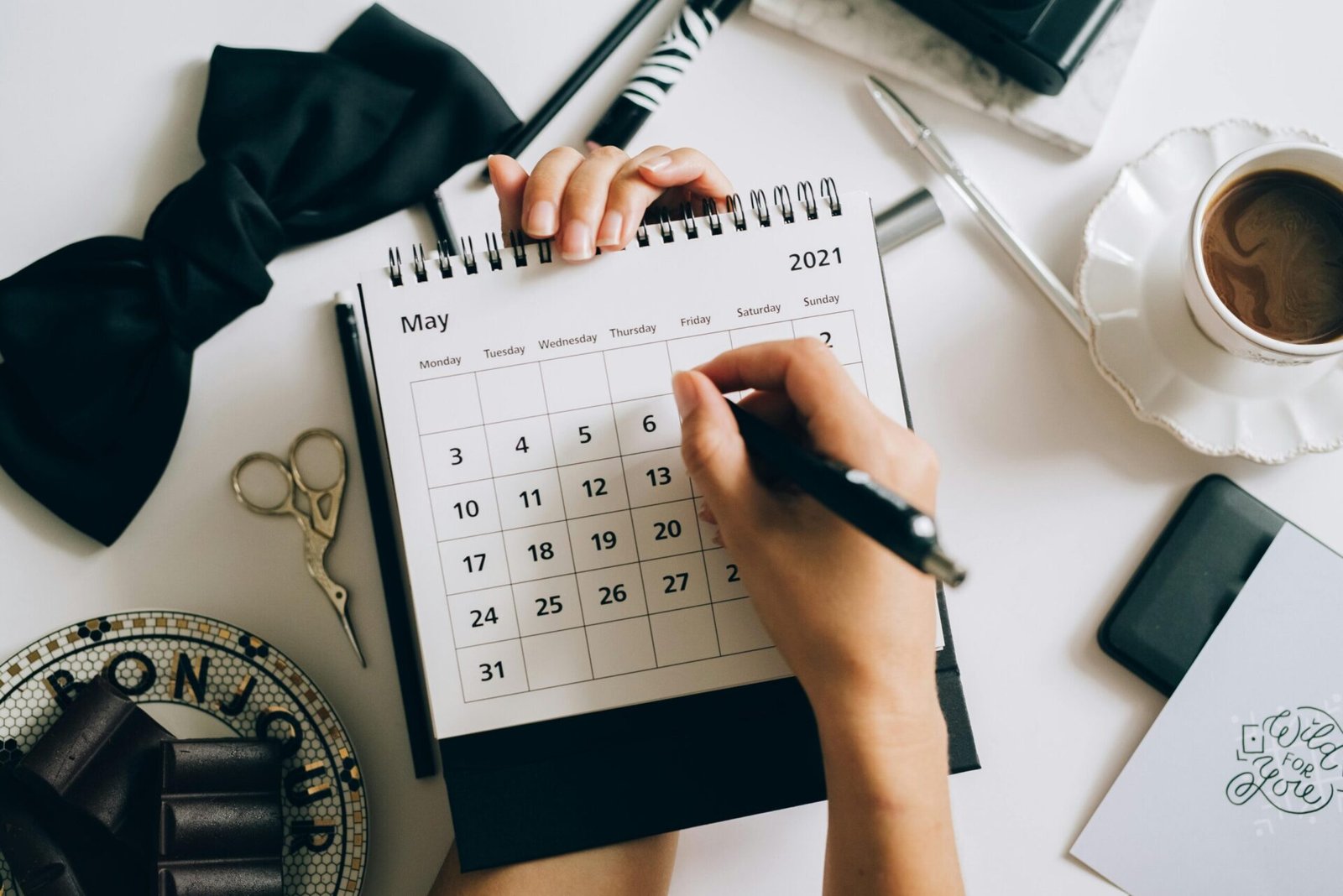 Person writing in notebook while planning their week