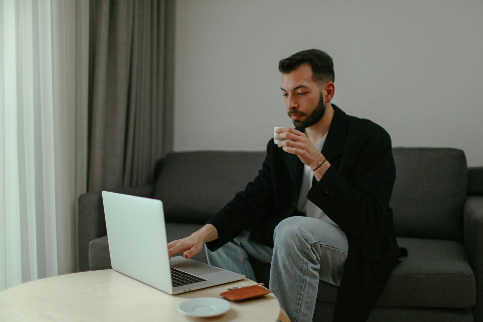 Person relaxed at laptop with coffee representing the relief of organized task management