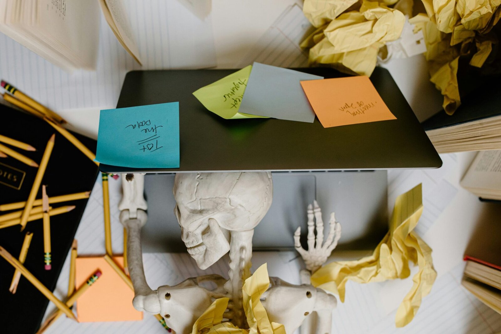 Messy desk covered with sticky notes representing task management overwhelm