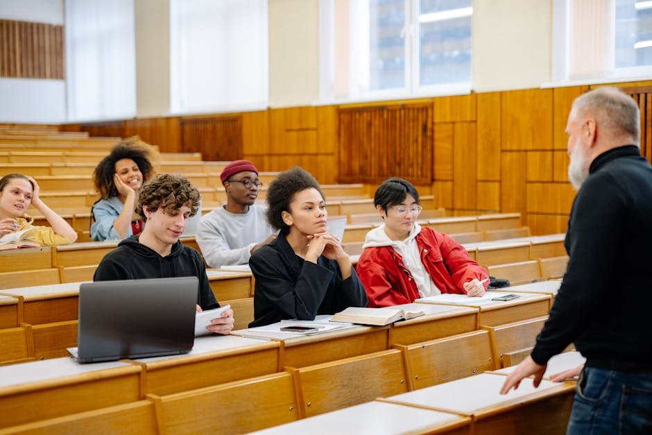 University students in a lecture hall following along on laptops