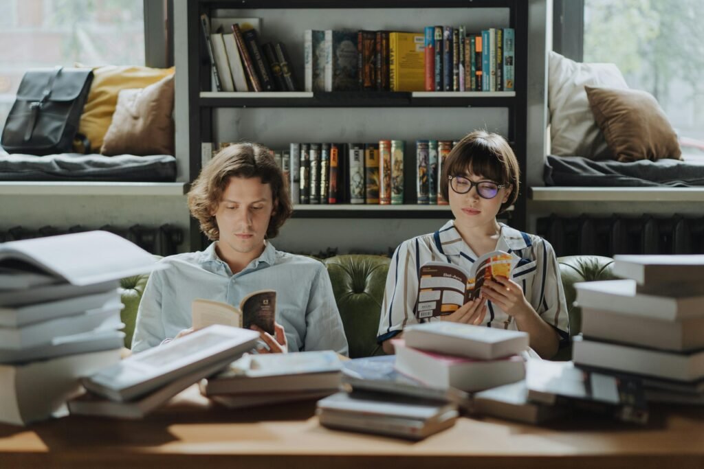 Two people enjoying a peaceful reading session surrounded by books in a cozy library atmosphere