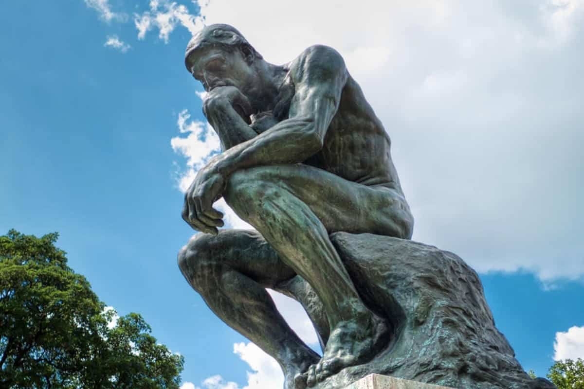 Auguste Rodin's The Thinker sculpture representing the decision between OpenAI Codex and Claude Code
