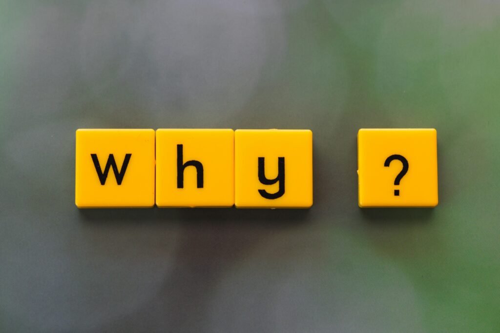 Yellow letter tiles spelling why, representing why AI scams 2026 keep fooling victims who don't understand current AI capabilities