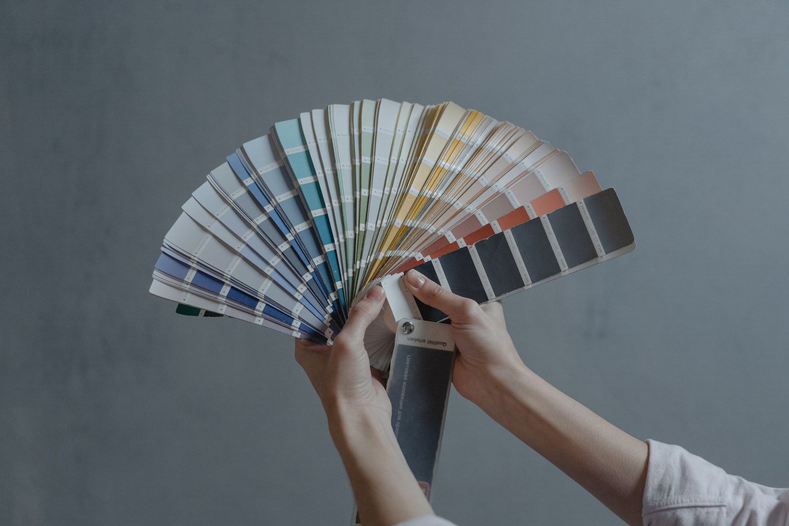 Hands holding a fan of color swatches, a metaphor for locked brand controls