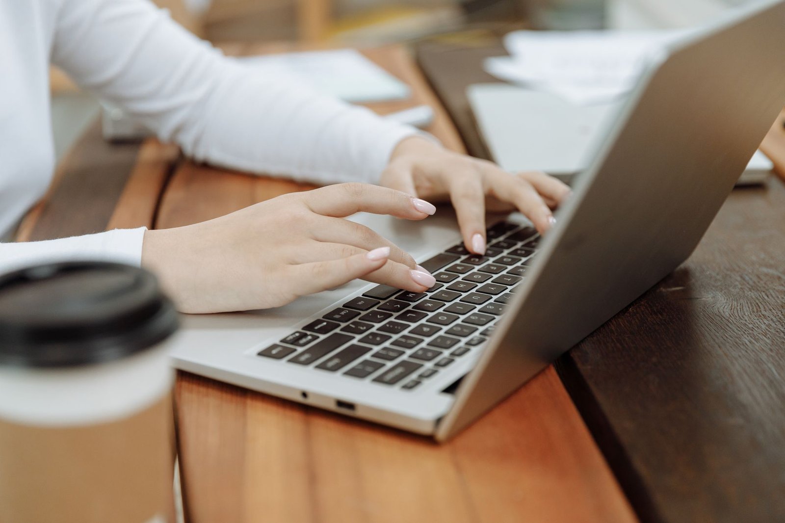 Hands typing on a laptop, using an AI presentation maker to draft a deck