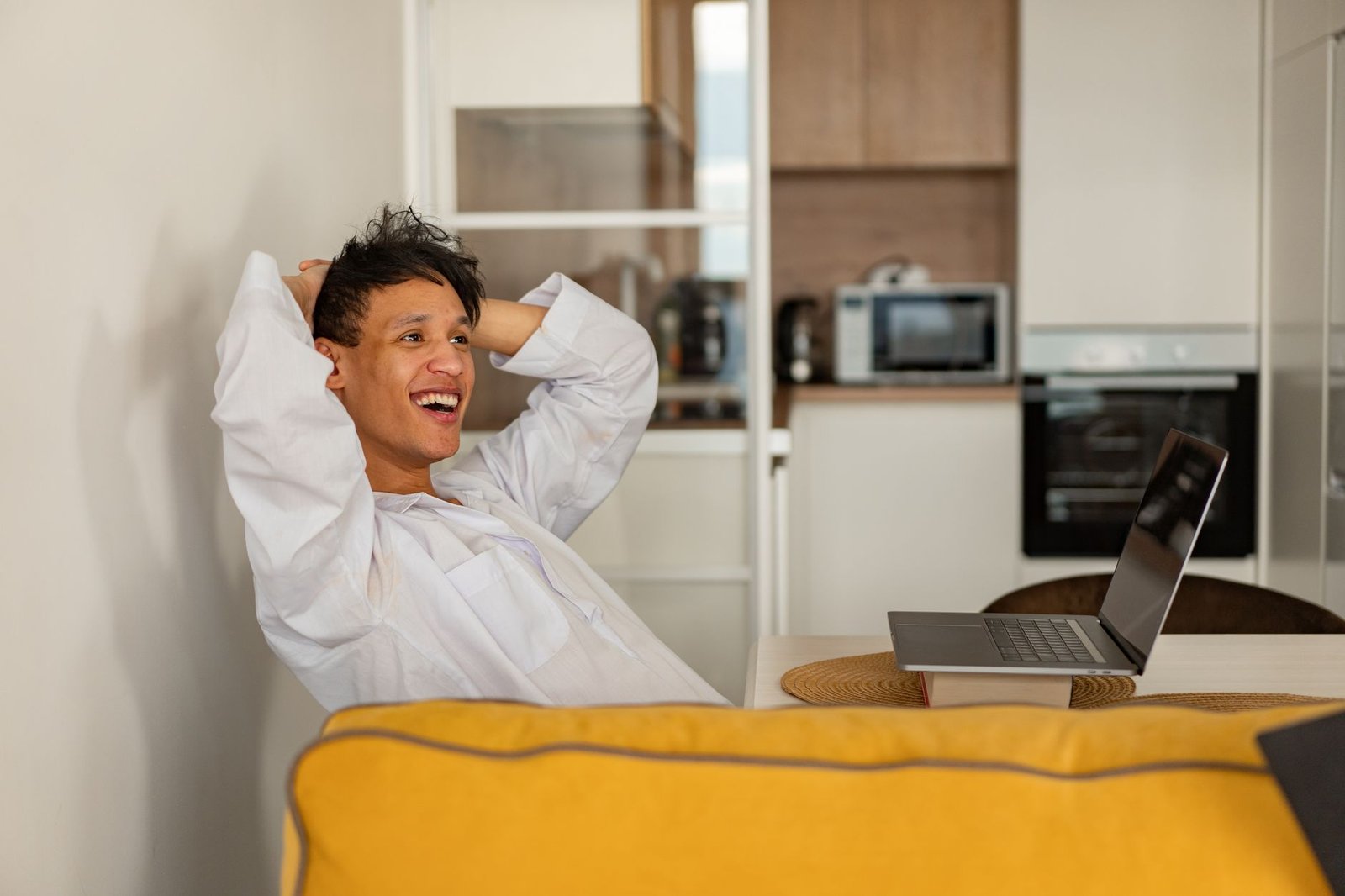 A relaxed person working on a laptop at home, not having to re-explain themselves thanks to ChatGPT memory