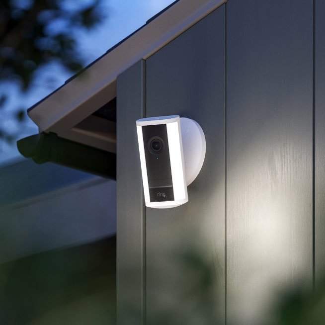 An outdoor security camera on a wall, the kind that can now deliver Ring Active Warnings automatically