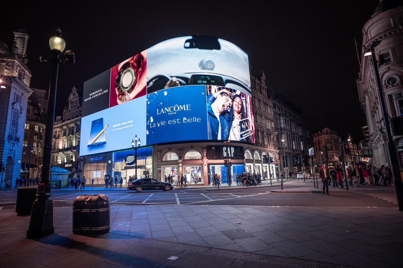 Illuminated billboards at night, representing the ads OpenAI now shows free ChatGPT users