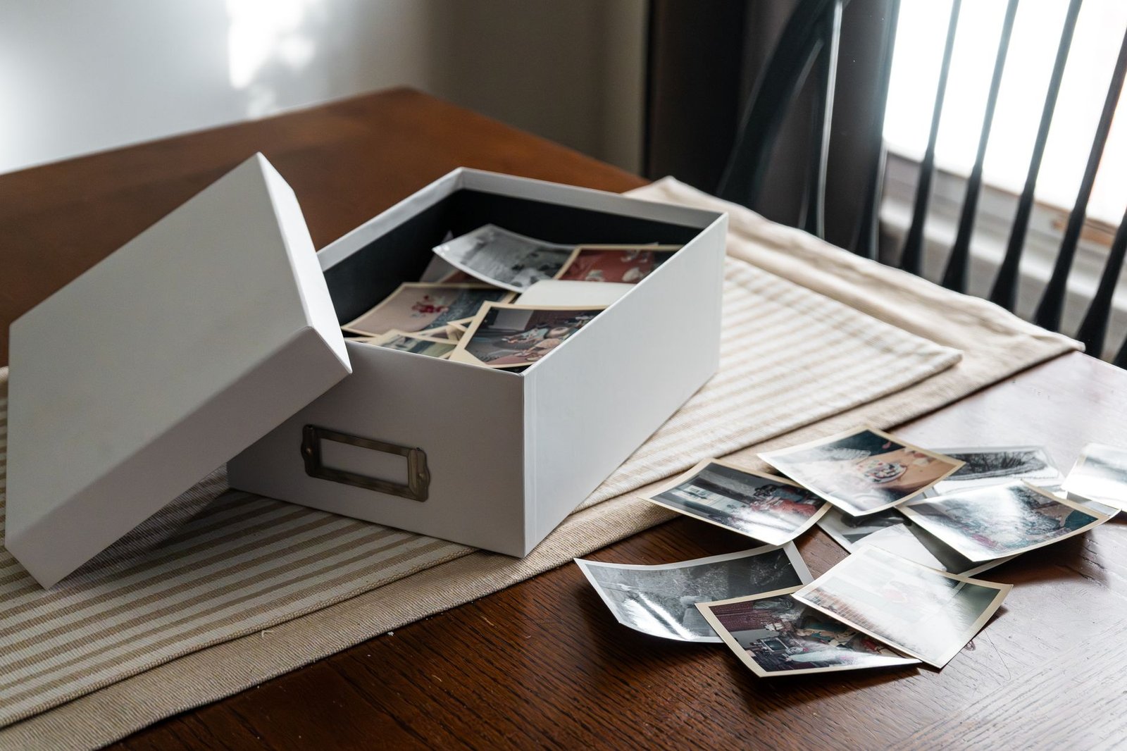 Open box of old photographs on a table, like the DALL-E images about to disappear from ChatGPT