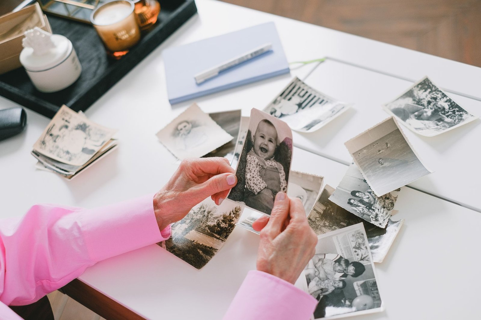 Person sorting through old photos on a table, like saving DALL-E images before the August 30 deadline