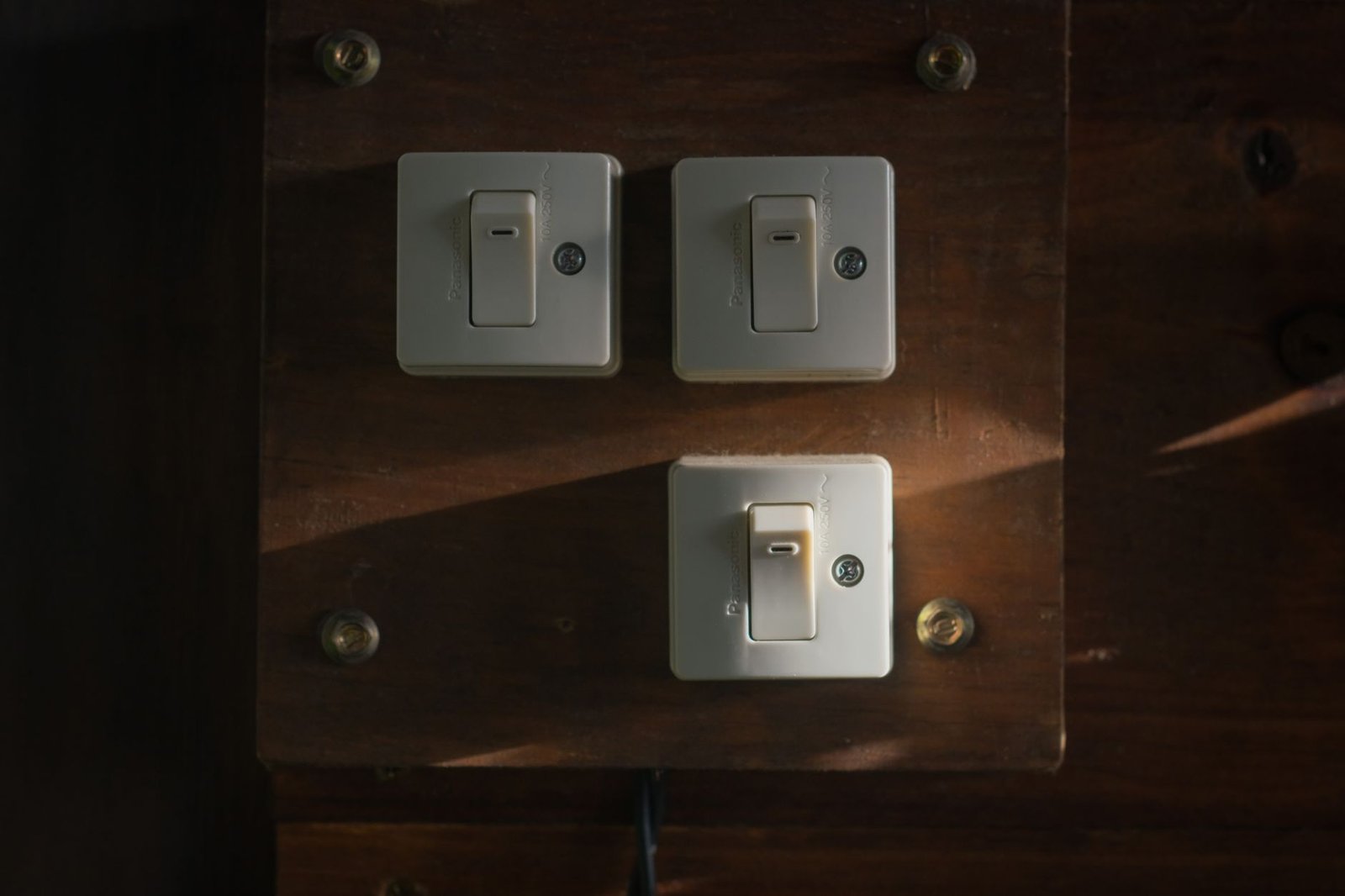 A row of vintage light switches on a wooden panel, standing in for the toggles in ChatGPT parental controls