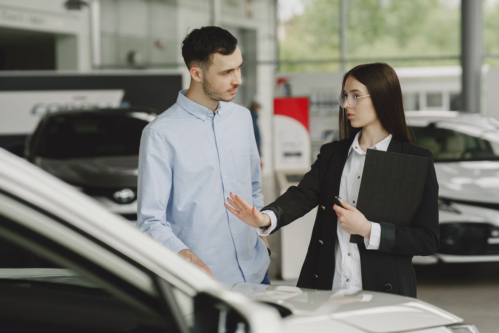 Salesperson talking with a customer in a showroom, the in-person version of what ChatGPT sponsored agents do inside a chat