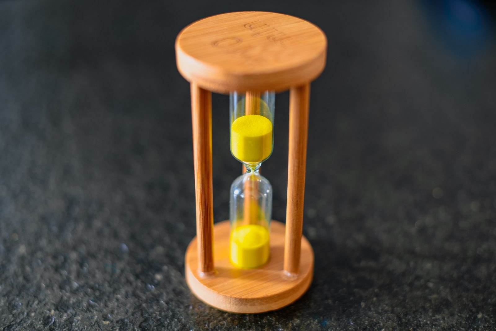 Wooden hourglass with yellow sand, standing in for how long iOS 27 battery drain lasts