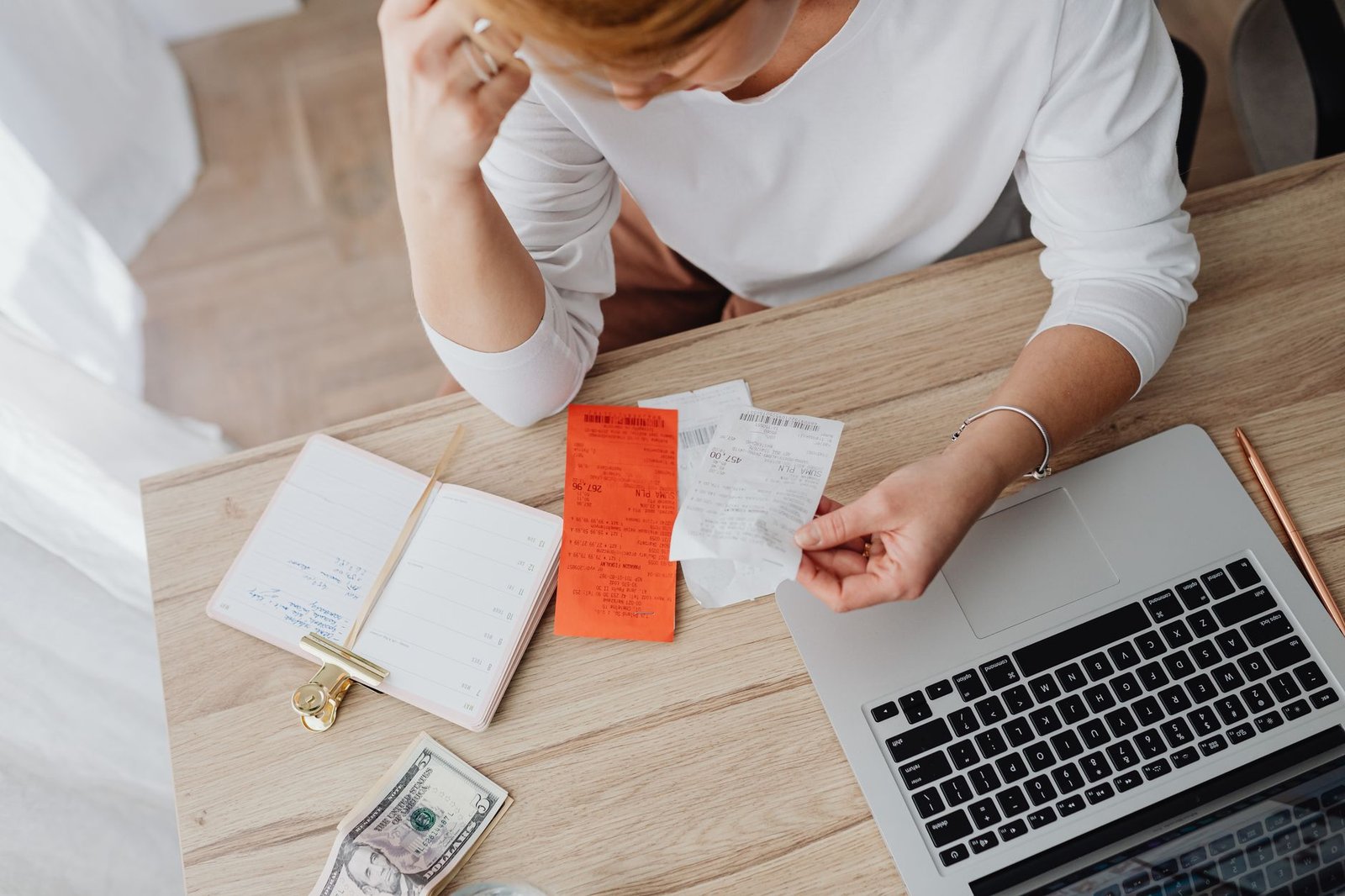 Person going through receipts at a laptop, deciding whether to connect a bank account to ChatGPT